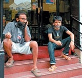 Smokers killing time outside a coffee shop, before joining their friends inside.DH Photo/ Dinesh SK