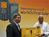 Samsung SW Asia HQ President and CEO J.S. Shin (L), and Minister for Renewable Energy Farooq Abdullah with the first solar powered mobile phone. AP