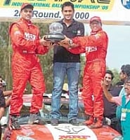 Team MRFs Arjun Balu (left) and Sujith Kumar receive the trophy from Indian skipper Mahendra Singh Dhoni after winning the K-1000 rally on Sunday.