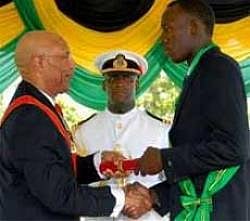 Usain Bolt, (R), shakes hands with Governor General Sir Patrick Allen after being decorated with the Order of Jamaica in Kingston. AP