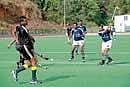 Ammathi Sports Club and Begur Eshwar Sports Club teams in action at the Kodagu district A division hockey tourney in Madikeri. DH Photo
