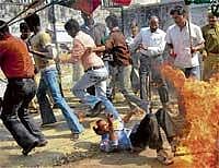 A Samajwadi Party activist tries to escape the fire that engulfed him when he and  other party workers were burning an effigy of MNS chief Raj Thacker