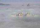 under cloud: A view of the rooftops of buildings covered with fog in Wenling town of China on Wednesday. AfP