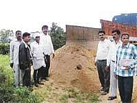 Officials of Mines and Geology Department seizing a lorry transporting sand near Thammireddyhalli in Mulbagal taluk on Wednesday. DH Photo