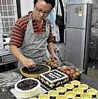 A staff decorating a cake. Dh photos by shivakumar B H