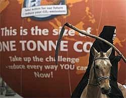 A man dressed as death on horseback holding a scythe, rides past a balloon indicating the volume of one tonne of carbon dioxide, outside parliament in Copenhagen Monday. AP