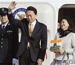 Japan's Prime Minister Yukio Hatoyama waves as his wife Miyuki looks on before boarding a special plane at Tokyo's Haneda airport on Sunday Dec. 27, 2009. Hatoyama left for India for talks with his Indian counterpart Manmohan Singh in New Delhi. AP