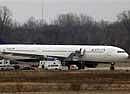 Northwest Airlines flight 253 sits on the tarmac after requesting emergency help at Detroit Metropolitan Airport in Romulus, Mich., on Sunday. A passenger onboard the same Northwest Airlines flight that was attacked on Christmas Day was taken into custody in Detroit on Sunday after becoming verbally disruptive upon landing, officials said. AP