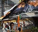 BJP workers  tear a poster of Hindi movie '3 Idiots' demanding the ban of a suicide scene in the movie following two suicide cases in Mumbai on Monday. PTI