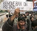 Activists of Jammu Kashmir Democratic Youth Federation shout slogans during a protest against the ban on pre-paid cell phones in Srinagar. File photo/AP