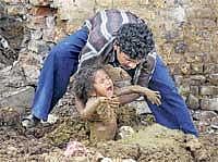 BLIND BELIEF: A polio-affected child being partially burried in mud during eclipse . DH Photo