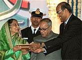 RBI Governor D Subbarao presents a memento to President Pratibha Patil as Finance Minister Pranab Mukhejee looks on, at the Platinum Jubilee celebration of Reserve Bank of India in New Delhi on Saturday. PTI