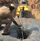A policeman directs the driver of a crane to the borehole into which the boy fell, in Warangal on Monday. AFP