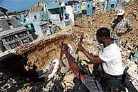 Haitians throw corpses into a common grave at a cemetery in Port-au-Prince. AFP