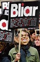 For justice: A demonstrator wearing a Tony Blair mask holds a placard during a protest, as Britains former prime minister gives evidence to the Iraq Inquiry at the Queen Elizabeth II Conference Centre in central London on Friday. REUTERS