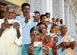 Beneficiaries display their cards at the distribution of 12 millionth smart card under Rashtriya Swasthya Bima Yojana at Vidhana Soudha in Bangalore on Tuesday. DH Photo