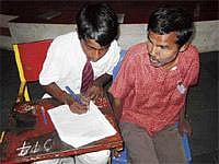 Enabling the Disabled: A scribe assisting a visually challenged student to write SSLC examination. DH Photo