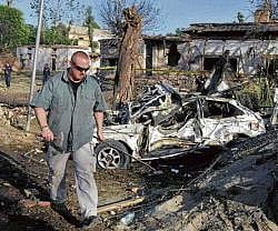 A US official examines the site of a suicide attack outside the US consulate in Peshawar on Monday. AFP