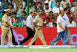 Vigilant eyes: City police commissioner Shankar Bidri (front right) takes stock of the situation after the bomb blast outside the Chinnaswamy stadium on Saturday. DH photo