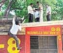 Investigating officials climb  the gate of Chinnaswamy Stadium on Tuesday, where a live bomb was found during Saturdays IPL match.  DH photo