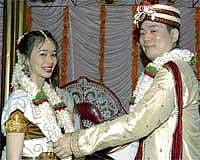 Tavon garlanding Asuka during their marriage as per Hindu tradition at a temple in Hattiyangadi. DH Photo