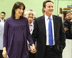British opposition Conservative party Leader David Cameron (right) and his wife Samantha arrive at the count centre in Witney on Friday. AFP
