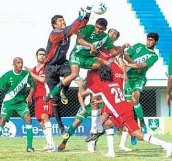 ONGC goalkeeper Bilifung Narzary rises high to thwart a strong challenge from HASCs Jai Kumar (5) at the Bangalore Football stadium on Monday. DH Photo