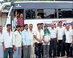 Agriculture Department assistant director Dhananjaya flagging of five buses carrying farmers to Kudalasangama, in Bangarpet on Saturday. DH Photo