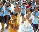 Children of the Government school in Kurubarpet of Kolar at the prayer meeting on the first day of the academic year on Monday. DH PHOTO