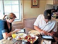 Kord Campbell with his wife Brenda each one of them engrossed in their own electronic gadgets. NYT