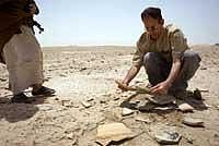 Valuable Evidence:  Archeologist Abdulamir al-Hamdani inspects broken pottery from a giant vase at the ancient site of Dubrum, a Sumerian city, buried near Dhahir, Iraq. NYT
