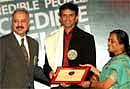 President & CEO of Coca-Cola India, Atul Singh (left) and LBR Editor Vijaya Ghose presenting 'People of the Year' award to cricketer Rahul Dravid at a function organised by Limca Book of Records (LBR) in New Delhi on Monday. PTI