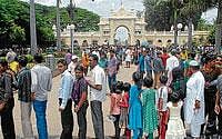 Tourists pouring : Visitors queueing up to the ticket counter outside the Mysore Palace as the number of tourists surge phenomenally in Mysore. (below) A filthy road behind KSRTC suburban bus stand, in Mysore. Dh Photos by Anurag Basavaraj