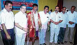 Higher Education Minister Dr V S Acharya and Dr G Shankar congratulating physically  challenged person Manjunath Naik who donated blood in the blood donation camp arranged by G Shankar Family Trust and the District Mogaveera Youth Association in Kundapur taluk on Saturday. District Congress President  Gopal Poojari and others look on. DH Photo