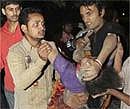 An injured Indian woman is helped at the scene of a building collapse in New Delhi, India on Monday.  AP Photo