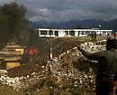 Onlookers watch as the wreckage of a crashed helicopter burns at Tawang. AFP
