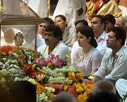 Legendary Indian cricketer Sachin Tendulkar, second from right, arrives to pay tribute next to the body of Hindu holy man Sathya Sai Baba during a public viewing at the Prasanthi Nilayam Ashram in Puttaparti- AP PHOTO