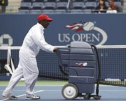 A worker clears water from the court at Arthur AShe Stadium during a rain delay at the U.S. Open tennis tournament in New York,AP Photo