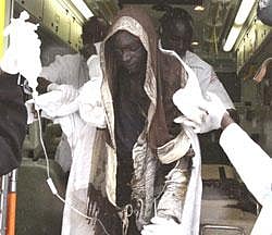 An injured person is helped from an ambulance as they were brought to Kenyatta National Hospital in Nairobi, Kenya, Monday, Sept. 12, 2011. A medical official says more than 80 people have been hospitalized after a petrol pipeline running through a slum in the Kenyan capital exploded. The number of people killed and the cause of Monday's explosion is unclear. Spokesman Fred Majiwa from St. John's Ambulance Service says that they have taken more than 80 people to hospitals around the Kenyan capital. He says many victims are burnt beyond recognition. The pipeline runs through the heavily populated slum of Embakasi between the city center and the airport. (AP Photo)