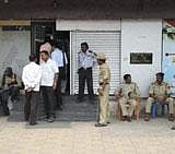 Policemen guard a bank during raid by a team of CBI to search lockers owned by Srinivas Reddy, brother-in-law of former Karnataka Minister G Janardhan Reddy in Bellary on Saturday. PTI Photo