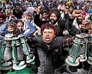 crippling stir : An employee of a state-run electricity board holds lanterns while shouting anti-government slogans in Chandigarh