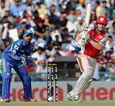 Mumbai Indians wicket keeper Dinesh Karthik (L) watches as Kings XI Punjab batsman Shaun Marsh plays a shot during the IPL Twenty20 cricket match between Kings XI Punjab and Mumbai Indians at PCA Stadium in Mohali. AFP Photo