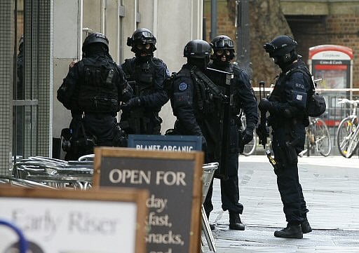 Armed police enter a building near Tottenham Court Road in London, Friday, April 27, 2012, after a woman reported that a mentally unstable man had walked into her office threatening to blow himself up. (AP Photo/Kirsty Wigglesworth)