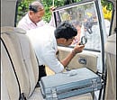 A forensic expert inspects the car after the robbery at RT Nagar in Bangalore on Monday. DH Photo