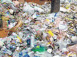 Garbage being dumped at Kalcharpe dumping yard without being processed, at Sullia. (Inset) Owing to the dumping of the garbage, the surrounding wells have been polluted.