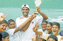 three cheers: (Left) Children surround second seed Vishnu Vardhan as he holds Zuari Garden City ITF Mysore Open trophy aloft at Mysore Tennis Club Courts in Mysore on Saturday. (