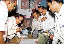 Last minute preparations: A R Raghavendra Rao, shirastedar in the election branch of the Kolar deputy commissionrs office, distributes poll materials to the officers on election duty on Saturday, ahead of Sundays council election.
