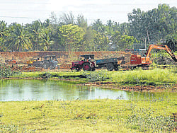fresh Lease of life: Excavators work to clear debris and waste collected at Bogadi Lake in Mysore. dh photos by Mamatha M R
