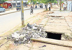 Waste dumped outside the drainage on B Rachaiah double road in Chamarajanagar. dh photo