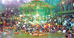 Assembly Speaker K G Bopaiah, District-in-Charge Minister Appachu Ranjan, Bhagandeshwara-Talacauvery Temple Managing Committee President Manu Muthappa, TP President Kavitha Prabhakar, AC G Prabhu and others at a meeting in Madikeri on Saturday. (Right) A file photo of devotees taking part in Tulasankramana at Talacauvery. DH PHOTO
